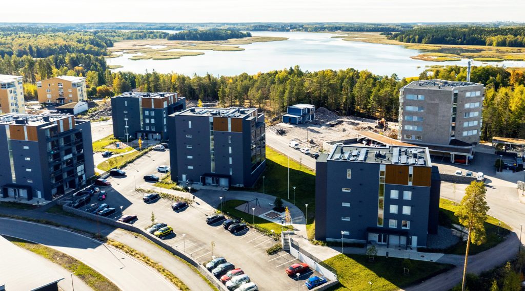 Ilmakuva, jossa näkyy kerrostaloja ja taustalla vesistöä.